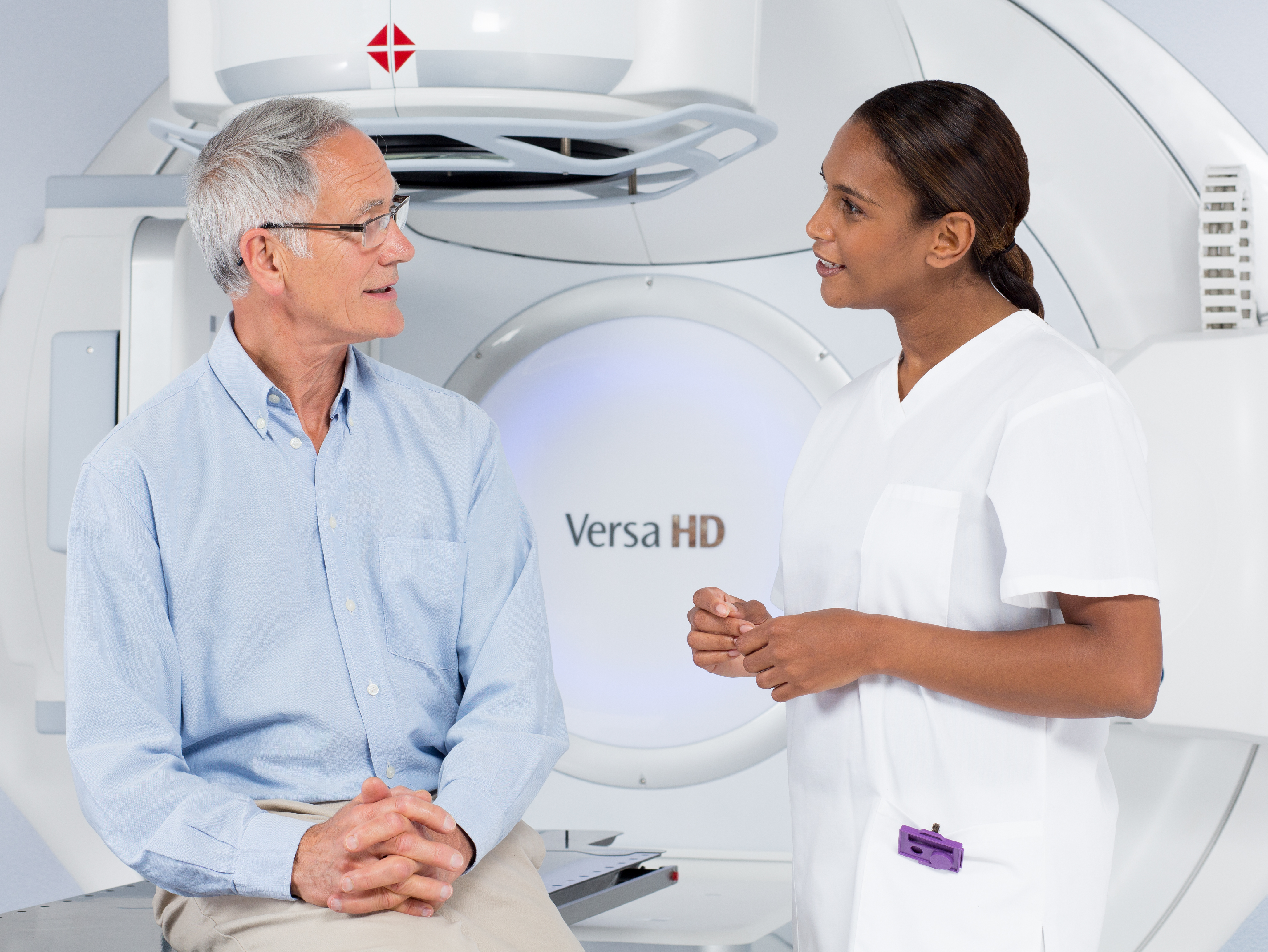 a medical professional talks to a patient with a medical device in the background