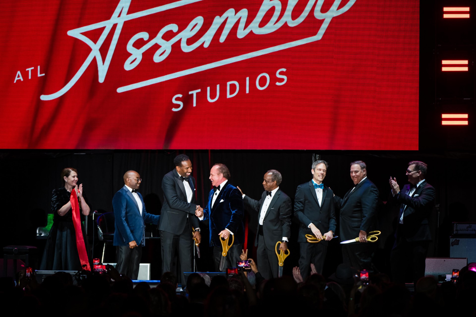 A group of people shake hands on stage at Assembly Atlanta, a film studio complex in Doraville