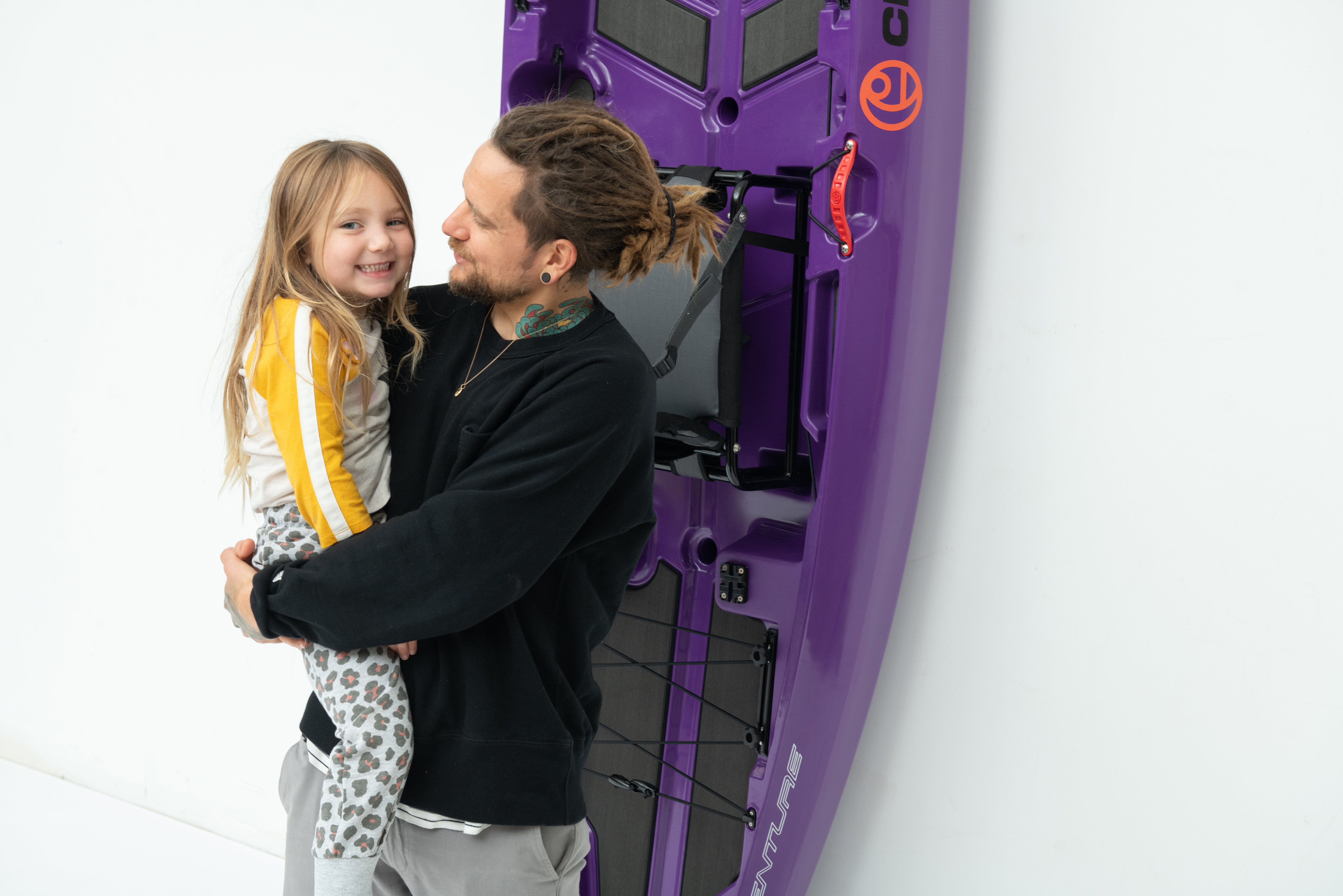 Crescent Kayaks owners smiles at a child with a kayak in the background