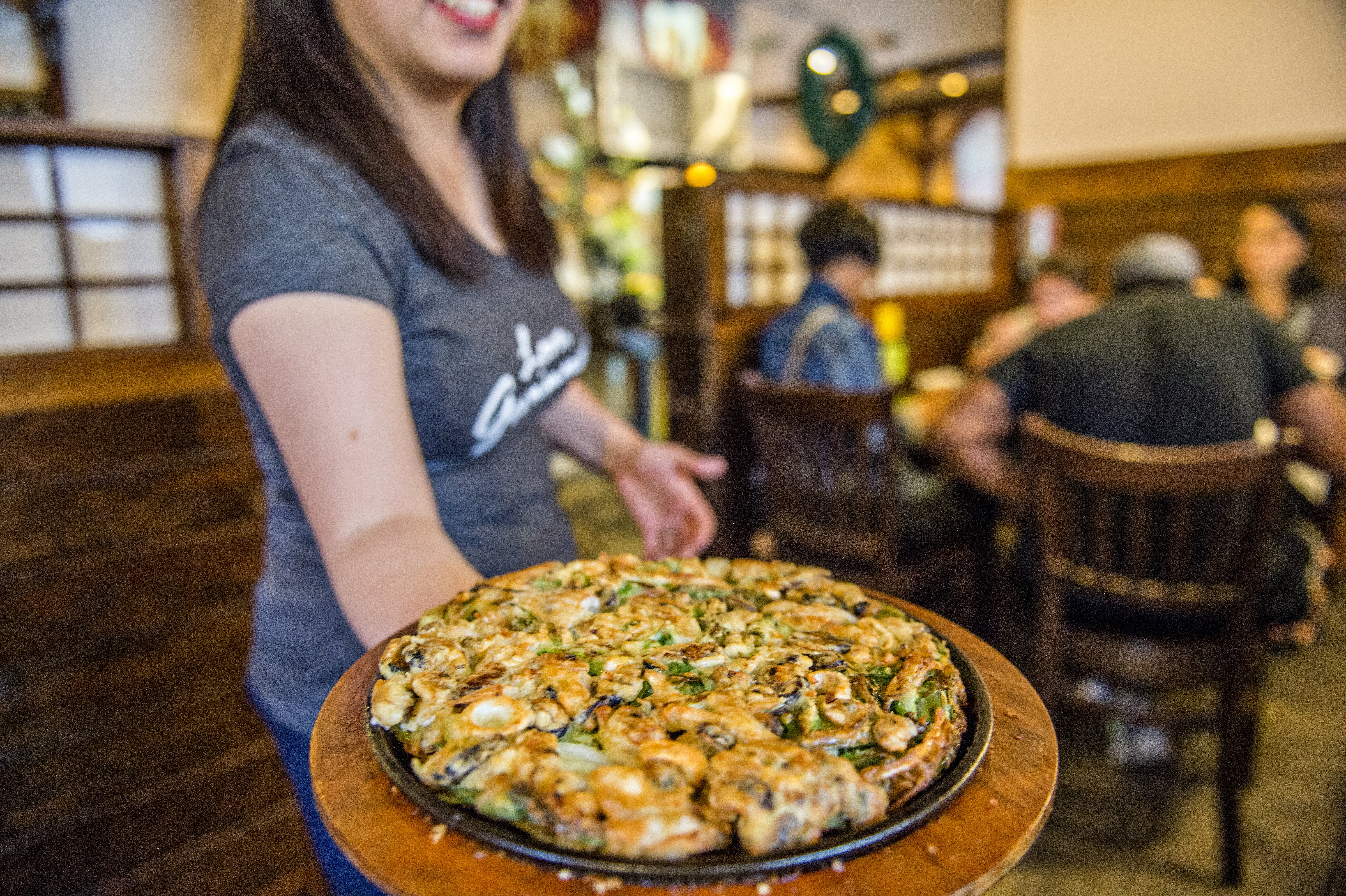 A server presents a tray of delicious Korean food at a restaurant on the Seoul of the South Tour