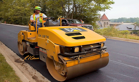 Worker driving a large piece of Caterpillar equipment