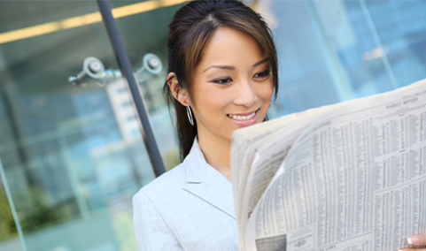 A woman reading a newspaper