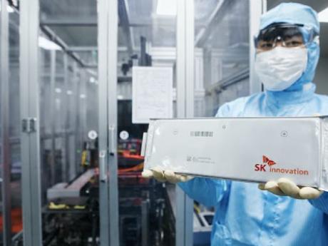 Photo Credit: Korea Bizwire manufacturing employee in korea holding up sk innovation ev battery