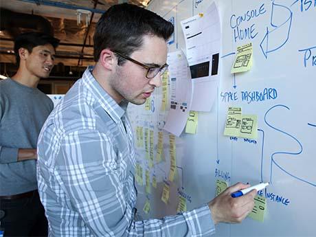 two people work on a white board