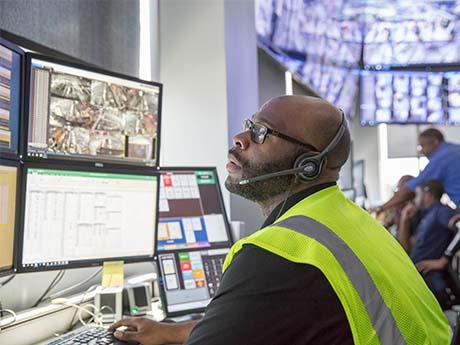 man with headset looks at screens