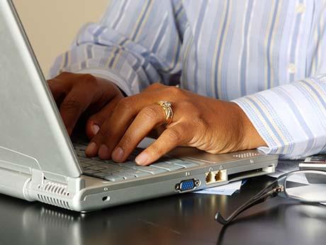 Technical Assistance person types on laptop