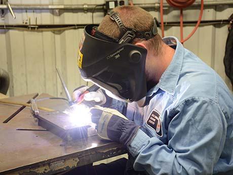Workforce Solutions person welding wearing a welding mask