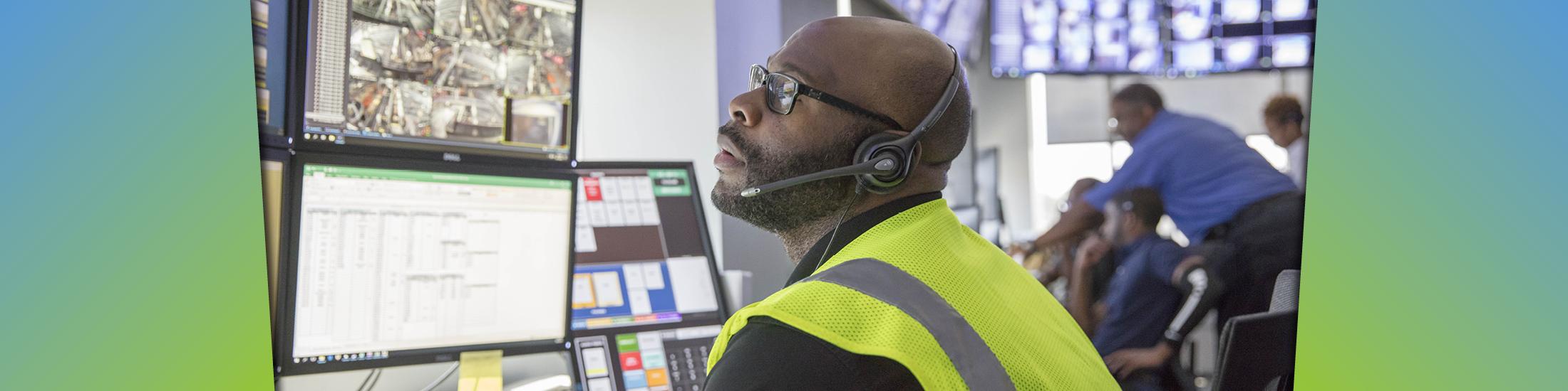man wearing headset looks at monitors in Georgia business